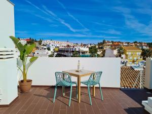 een tafel en stoelen op een balkon met uitzicht bij CASINHA DE FERRAGUDO - Terraço Privado, AC, WiFi, Centro 250m in Ferragudo