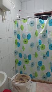 a bathroom with a shower curtain with a toilet at Recanto dos Jardim's Arraial do Cabo in Arraial do Cabo