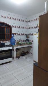 eine Küche, die mit einer Theke und einem Kühlschrank umgebaut wird in der Unterkunft Recanto dos Jardim's Arraial do Cabo in Arraial do Cabo