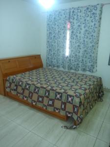 a small bed in a room with at Recanto dos Jardim's Arraial do Cabo in Arraial do Cabo