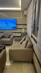 uma sala de estar com um sofá e uma televisão em فندق السد الخليجى em Sīdī Ḩamzah