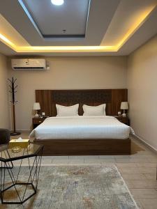 una camera con un grande letto e due tavoli di فندق السد الخليجى a Sīdī Ḩamzah