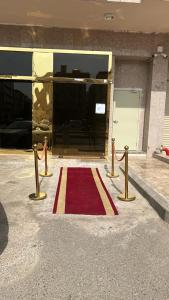 a red and yellow rug in front of a building at فندق السد الخليجى in Sīdī Ḩamzah
