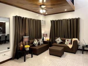 a living room with two brown couches and a table at Charming 3-Bedroom Country Farm Home Pool ParkSprings Lipa in Lipa