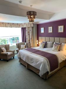 a bedroom with a large bed and a purple wall at Glendower House in Minehead