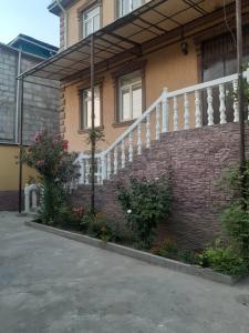 a brick building with a white railing and a staircase at 3 floor quite cottage in Dushanbe in Dushanbe