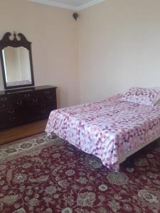 a bedroom with a bed with a dresser and a mirror at 3 floor quite cottage in Dushanbe in Dushanbe
