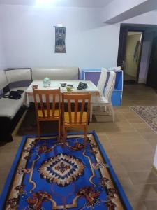 a living room with a table and two chairs and a rug at 3 floor quite cottage in Dushanbe in Dushanbe
