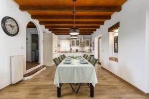 a dining room with a table and a clock on the wall at Villa Marijanin Vrt in Tinjan