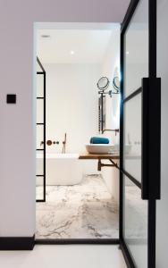 a bathroom with a mirror and a tub at Boutique Hotel De Salon in The Hague