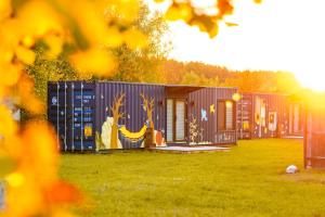 a row of shipping containers with a painting on them at Arche Siedlisko Rogacze 72 in Milejczyce +22 photos