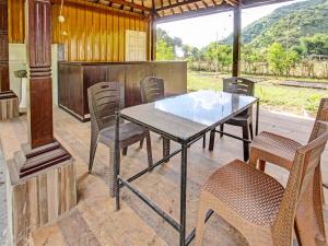 een glazen tafel en stoelen op een patio bij OYO 91830 Hotel Gemilang 2 in Lombok