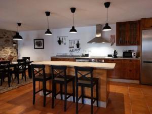 a kitchen with a island with bar stools at Casa Férias Retiro do Rodeiras in Figueira de Castelo Rodrigo