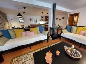 uma sala de estar com dois sofás e uma lareira em Casa Férias Retiro do Rodeiras em Figueira de Castelo Rodrigo
