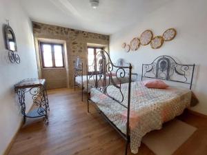 1 dormitorio con 2 camas de hierro en una habitación en Casa Férias Retiro do Rodeiras, en Figueira de Castelo Rodrigo