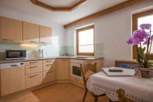 a kitchen with a table with a vase of purple flowers at Ferienwohnung Unterperler in Hippach