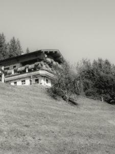 uma foto a preto e branco de uma casa numa colina em Schulhaus Tirol em Zell am Ziller