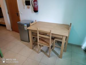 a wooden table and chair next to a trash can at AH Xamedu Sal Hostel in Santa Maria