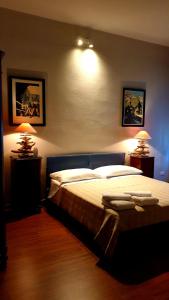 um quarto com uma cama grande com duas luzes em bb26 Piave apartment city center em Cremona