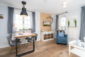 een woonkamer met een tafel en een blauwe stoel bij Wattperle in Rantum