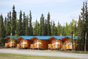 a row of wooden cabins with blue roofs at Tok RV Village and Cabins in Tok