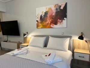 een slaapkamer met een wit bed en handdoeken bij City House Comfort 1 in Kalamata