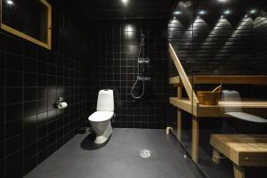 a black bathroom with a toilet and a sink at Black Work Levi Aihki in Kittilä +7 photos