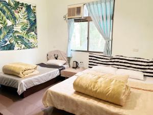 Habitación con 2 camas y ventana en 森霖旅宿, en Meinong