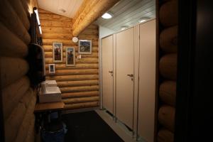 - un couloir d'une salle de bains avec des murs et des armoires en bois dans l'établissement Rafi - The Village of Silence, à Tepsa