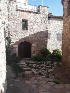 a large stone building with a door and a courtyard at Cal Tous, La Socarrimada in Rojals