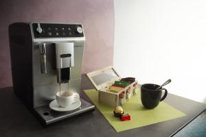 a coffee machine sitting on a counter with a cup at Residence La Quiete in Alba