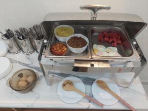 撒馬爾罕的住宿－Jahongir Premium，碗和汤匙的柜台上的食品托盘
