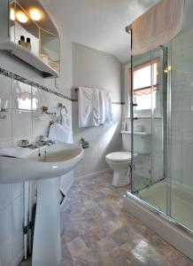 a bathroom with a sink and a shower and a toilet at Glendower House in Minehead