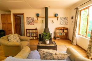 sala de estar con sofá y chimenea en Garden Cottage en Graaff-Reinet