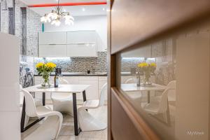 Apartament z historią, Klahra MyWeek في لوندك زدرووي: مطبخ بطاولتين بيض وكراسي بيضاء