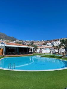 a large swimming pool in the middle of a green field at Malibu Park 2115 - Ocean View in Adeje