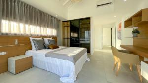 a bedroom with a large bed and a desk and a desk at Luxury Villa Beach and Putt avec accès plage in Saint-François +32 photos