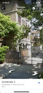 een hek voor een wit huis bij Loft Crimea con patio in Turijn