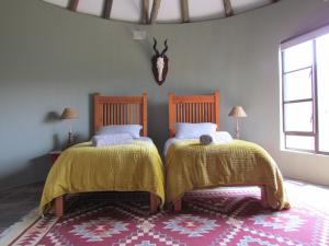 - une chambre avec 2 lits et des couettes jaunes dans l'établissement Zungah Lodge, à Uitenhage