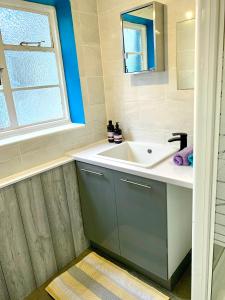 een badkamer met een wastafel en een raam bij 4Alma St in Plymouth