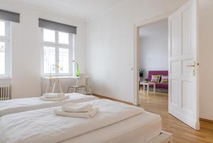 ein weißes Schlafzimmer mit zwei weißen Handtüchern auf einem Bett in der Unterkunft Kaiser-Friedrich in Berlin