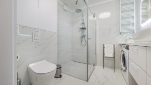 biała łazienka z prysznicem i toaletą w obiekcie Apartamenty Sun & Snow BLUE II w Sarbinowie