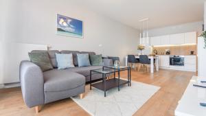 salon z kanapą i stołem w obiekcie Apartamenty Sun & Snow BLUE II w Sarbinowie
