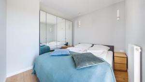 sypialnia z łóżkiem i dużym lustrem w obiekcie Apartamenty Sun & Snow BLUE II w Sarbinowie