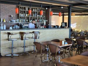 a man standing behind a bar in a restaurant at Hotel Neptun Kvariati in Kvariati