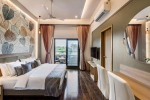 a hotel room with a bed and a mirror at SaffronStays Nishta - 4BR pet-friendly villa with pool, turf, gazebo & terrace BBQ views in Alibaug in Alibaug