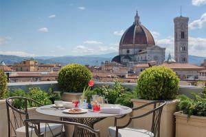 a table on a balcony with a view of a city at NH Collection Palazzo Gaddi in Florence