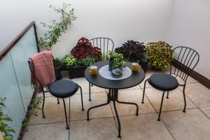d'une table et de chaises sur un balcon orné de plantes. dans l'établissement Apáca 30 Apartman **** Győr, à Győr