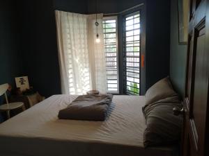 a bed in a bedroom with a large window at REQUELstore in Sungai Pelik