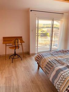 a bedroom with a bed and a desk and a window at Chez Georges - Maison 3 - les Gîtes du Verdon in Esparron-de-Verdon
